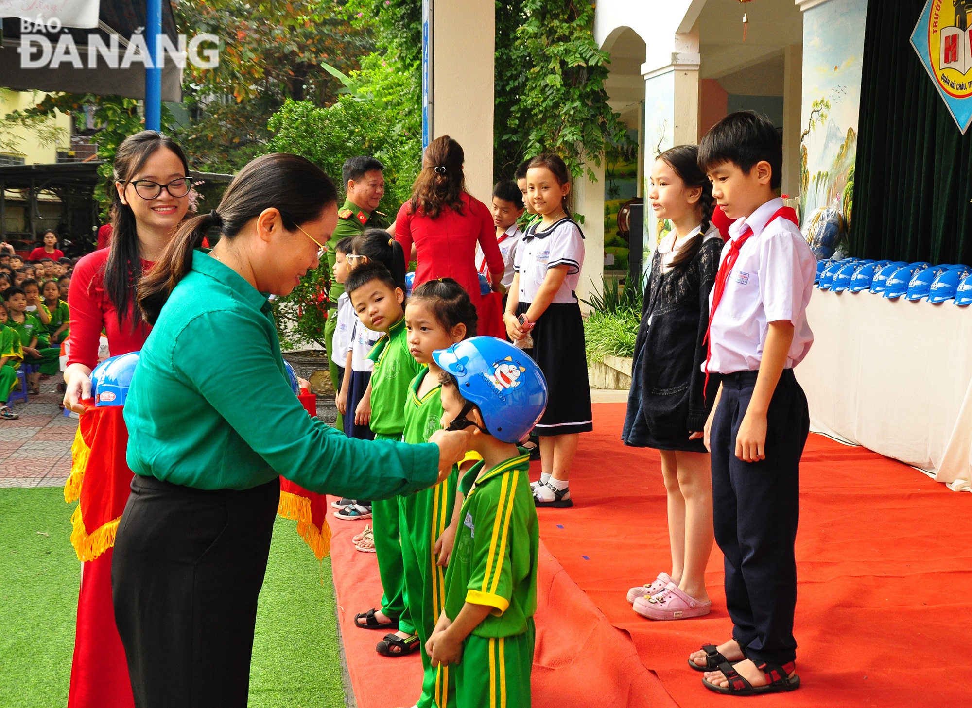 A representative of Hai Chau District People's Committee presenting helmets to Hung Vuong school pupils. Photo: THANH LAN