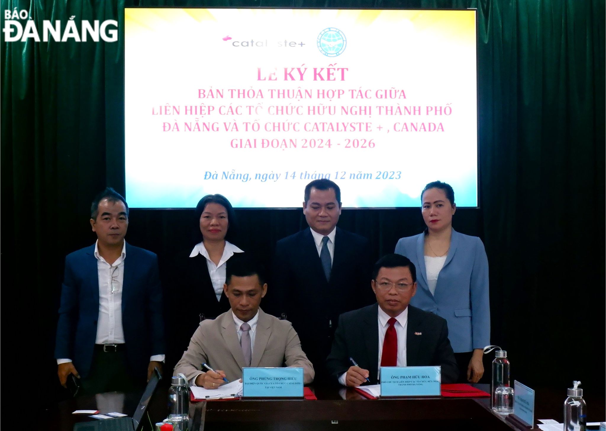 Chairman of the Da Nang Union of Friendship Organisations Nguyen Ngoc Binh (standing, second, right) witnessing the signing ceremony of the agreement between his unit and CATALYSTE+ organisation (Canada). Photo: T.P