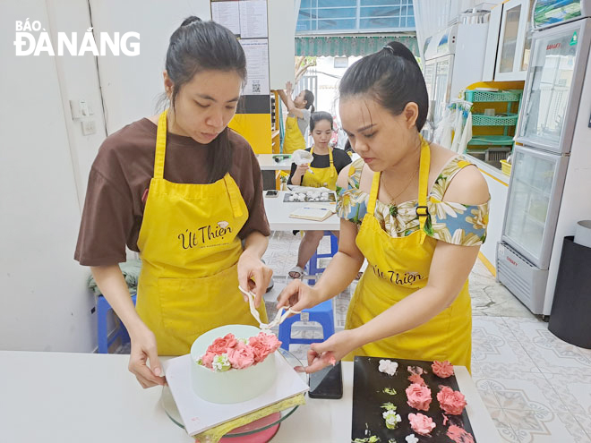 Teacher Duong Nguyen Ngoc Thien (right) guiding trainees on how to decorate a cake. Photo: KHANH HOA