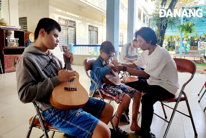 Mr. Truong Luong Hy is teaching piano to visually impaired children. Photo: P.C