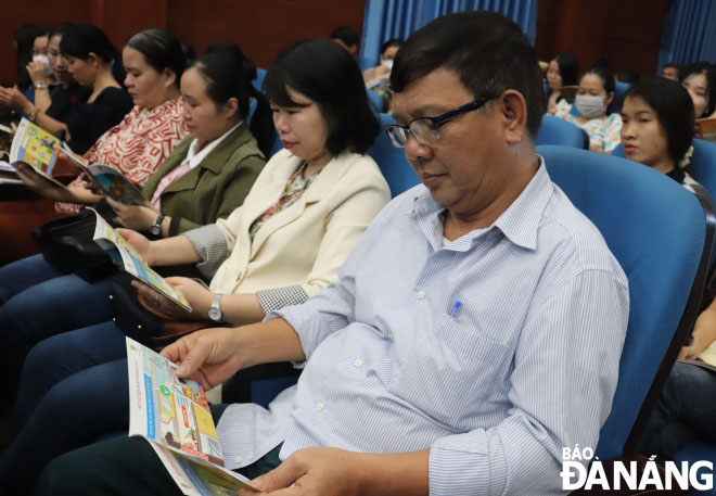 Teachers, staff, and workers are given fire prevention handbooks. Photo: NGOC HA