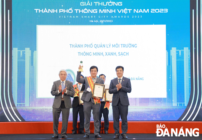 On behalf of the Da Nang authorities and people, Deputy Director of the Department of Natural Resources and Environment Dang Quang Vinh (middle) received the “smart, green and clean” city award at the awards ceremony in Ha Noi on November 30.. Photo: HOANG HIEP