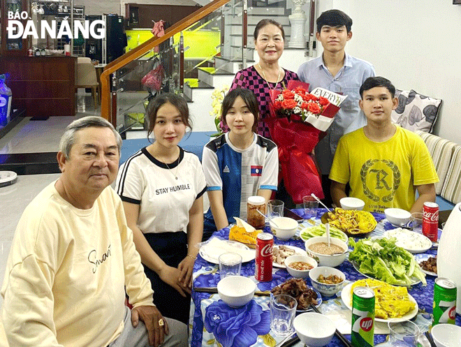 Mrs. Vu Thi Xuan Huong, her husband and their adopted children who are Lao students. Photo: DAC MANH