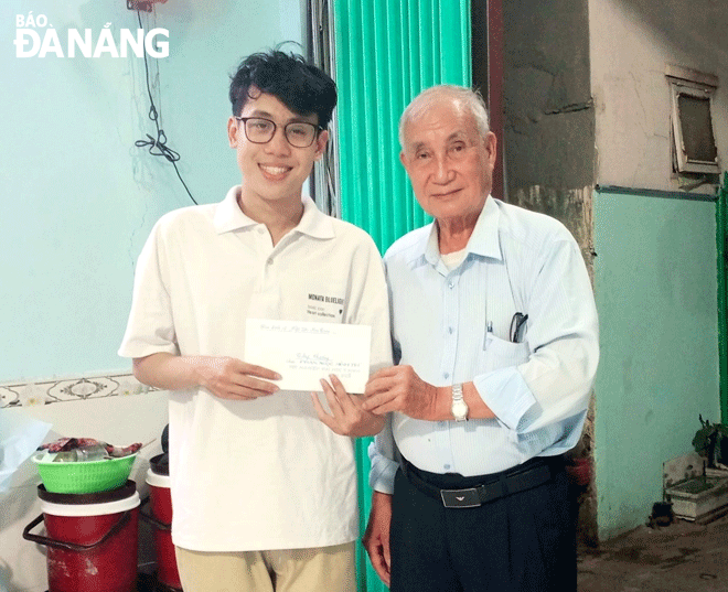 Mr. Nguyen Van Quynh (right), giving gifts to pupils who achieved good academic results in the 2022-2023 school year. Photo: T.P.