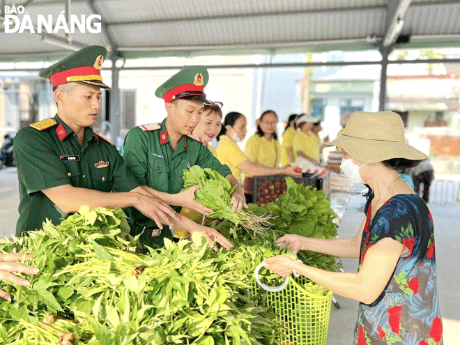 Military officers and men offering food to local disadvantaged households. Photo: LAM PHUONG