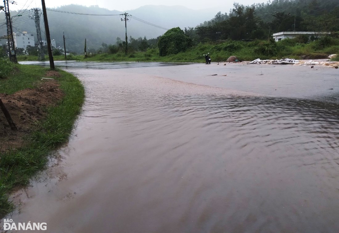 Mưa rất to ở khu vực suối Đá, phường Thọ Quang (quận Sơn Trà) làm nước từ sườn núi chảy ra gây ngập đường Lê Văn Lương. Ảnh: HOÀNG HIỆP