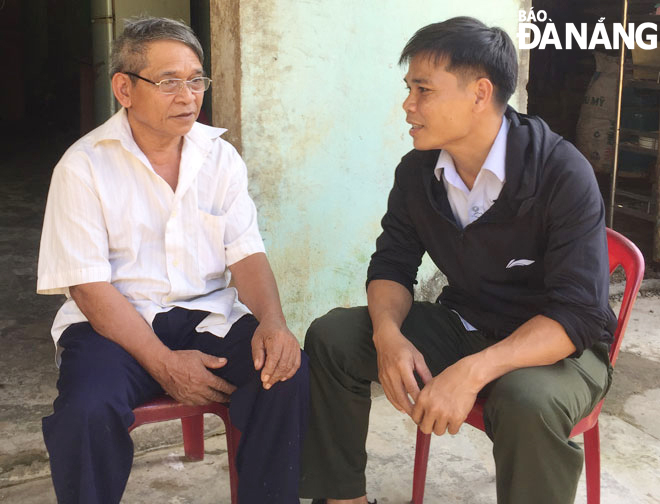Trưởng thôn Tà Lang Đinh Văn Hin (phải) thăm hỏi người dân trong thôn. Ảnh: X.S
