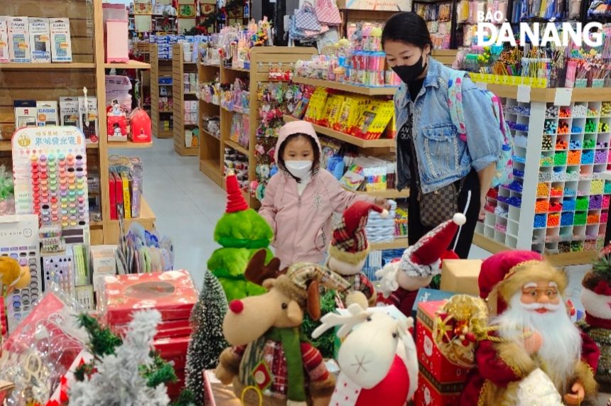 Some parents take their children to choose suitable products for Christmas. Photo: CHIEN THANG