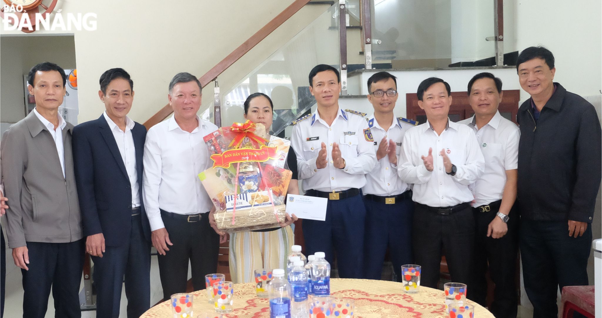 Head of the municipal Party Committee's Mass Mobilisation Board Le Van Trung (3rd, left) giving a gift to Mrs. Nguyen Thi Lap. Photo: T.AN