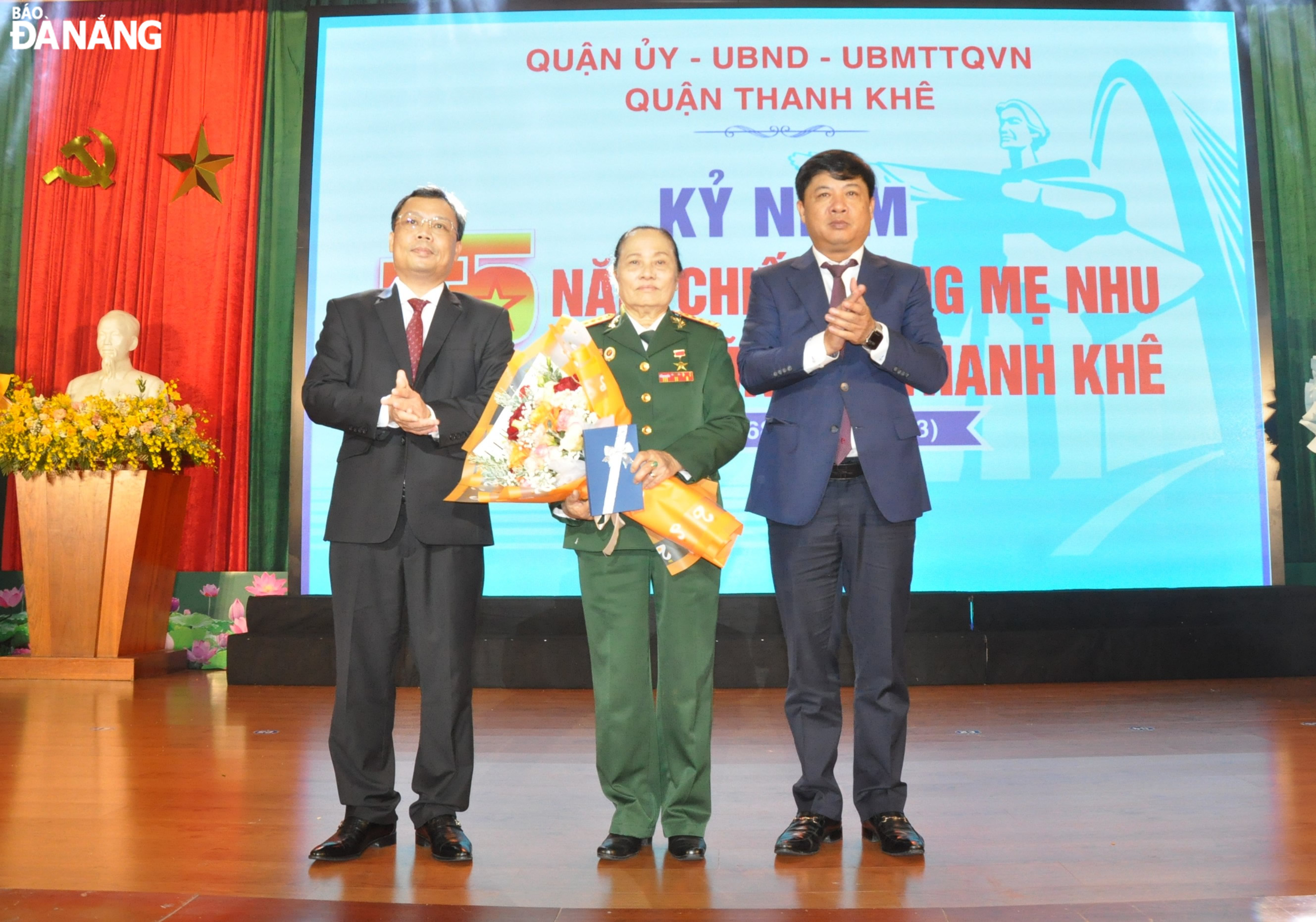 Deputy Secretary of the Da Nang Party Committee Luong Nguyen Minh Triet (right) and Secretary of Thanh Khe District Party Committee Le Tung Lam (left) presenting a  bouquet of flowers to Thanh Khe Hero, and Hero of the People's Armed Forces Nguyen Thi Tam. Photo: LE HUNG