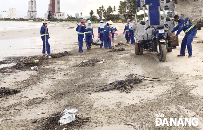 Environmental sanitation workers diligently cleaning up the beach. Photo: THANH LAN