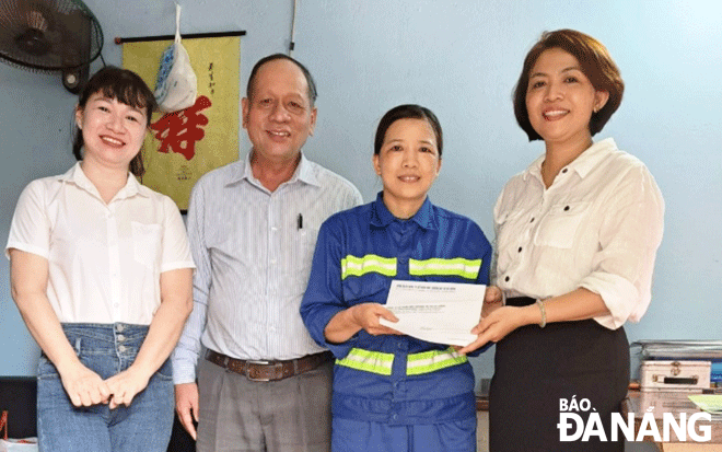 Leaders of the Da Nang Urban Environment JSC and the Hai Chau Environment Enterprise honoured worker Nguyen Thi Thuan (second, right) for her honesty  as she returned the lost property to its owner. Photo: NHAT HA.