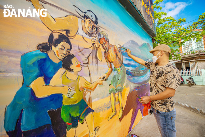 Họa sĩ đang hoàn thiện một tác phẩm tại đường bích họa ở tổ 12 phường Mân Thái (quận Sơn Trà).  Ảnh: ĐOÀN NGỌC THỊNH