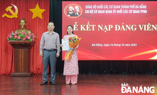 Phó Bí thư Đảng ủy khối Các cơ quan thành phố Hà Đức Hoài, Bí thư Chi bộ Cơ quan Đảng ủy khối Các cơ quan thành phố trao quyết định kết nạp Đảng cho đảng viên mới. Ảnh: PV