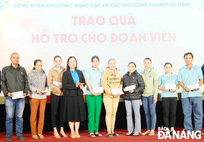 Công đoàn các cấp và doanh nghiệp nỗ lực chăm lo Tết cho đoàn viên, người lao động.  Trong ảnh: Phó Chủ tịch Liên đoàn Lao động thành phố Đinh Thị Thanh Hà (thứ 4, bên trái sang) trao quà cho đoàn viên khó khăn. Ảnh: XUÂN HẬU