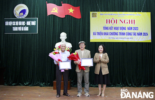 Chairwoman of the Da Nang Folk Arts Association Dinh Thi Trang (right) awarding the municipal-level Folk Arts Award to outstanding authors. Photo: X.D