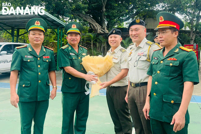 Lieutenant Colonel Doan Van Tinh (second, left) presenting welcome flowers to Singaporean young military officers who paid a visit and conducted exchanges with their Vietnamese colleagues in the Da Nang Border Port in 2023. Photo: BA VINH