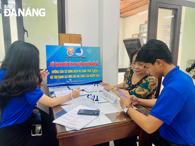 Đoàn viên thanh niên UBND phường Hòa Thọ Đông (quận Cẩm Lệ) hỗ trợ người dân sử dụng dịch vụ công trực tuyến. Ảnh: M.Q