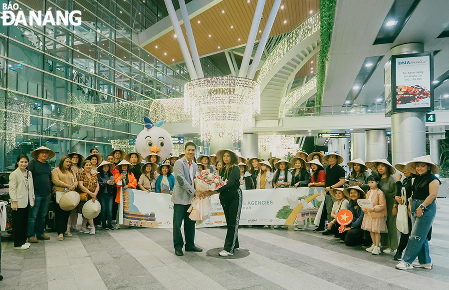Đại diện Công ty Du lịch Duy Nhất Đông Dương (hàng trước, bên trái) tặng hoa chào mừng đoàn tại Sân bay quốc tế Đà Nẵng. 