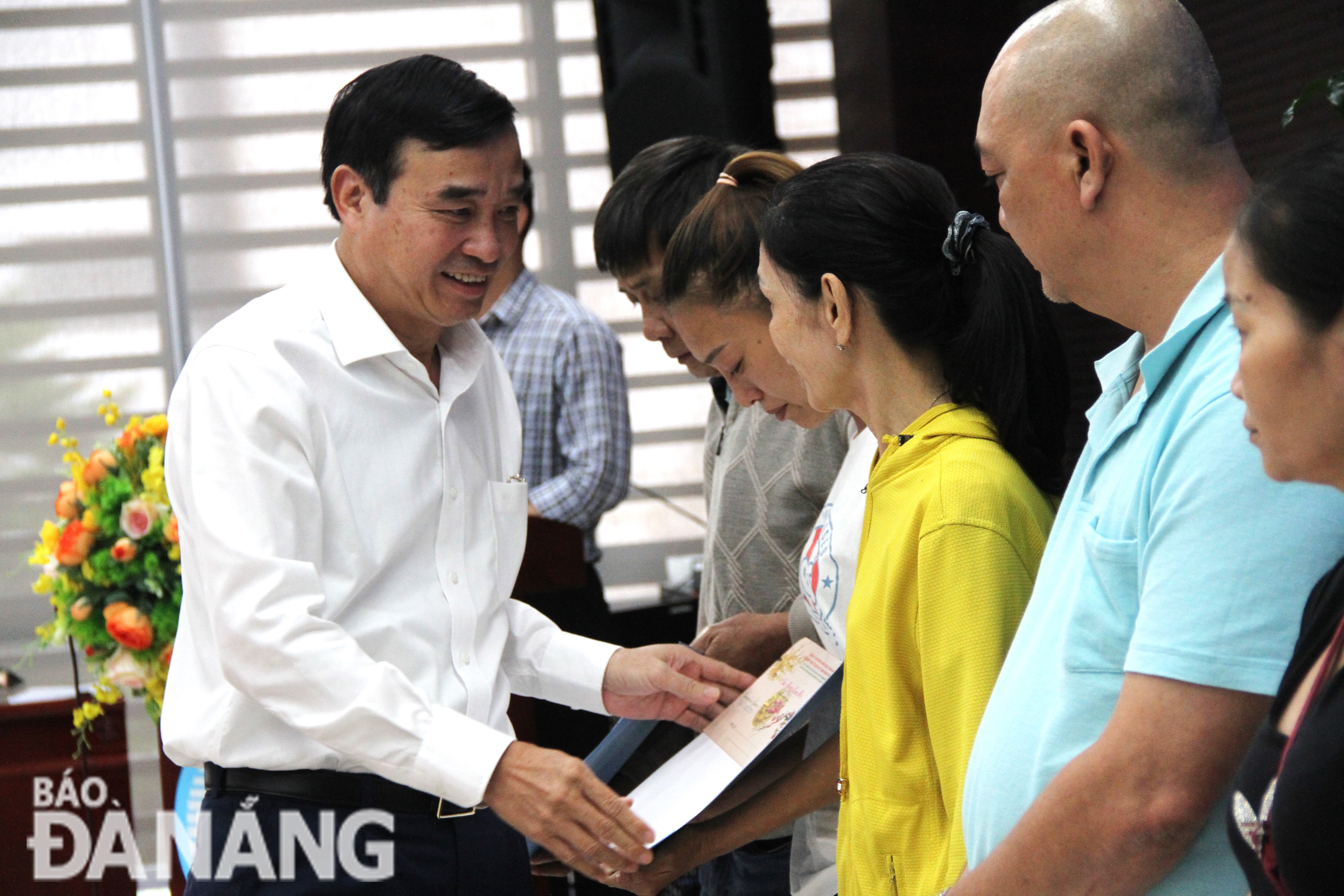 Chairman of the Da Nang People's Committee Le Trung Chinh (left) awards the decision to rent apartments to poor households in extremely difficult circumstances. Photo: L.P