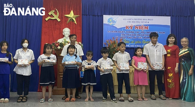 Ms Khai ( far right) presenting gifts to children.