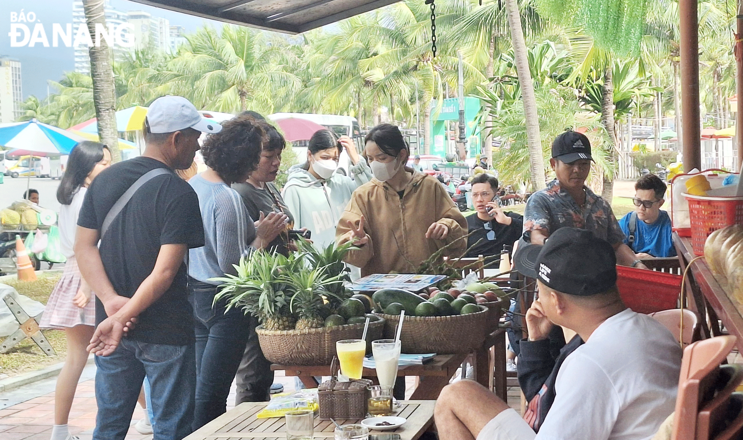 Tourists buying goods at a stall in the East Sea Park. Photo: NHAT HA