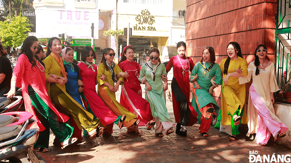 A family hailing from Quang Nam Province take photos with 'ao dai' at Da Nang's Han market. Ms. Nguyen Minh Thu (4th, right) shared that member of her family were impressed with beautiful photos with 'ao dai' on social networks, so they decided to take pictures together to create family memories. The family hired a photographer for VND3 million a day.