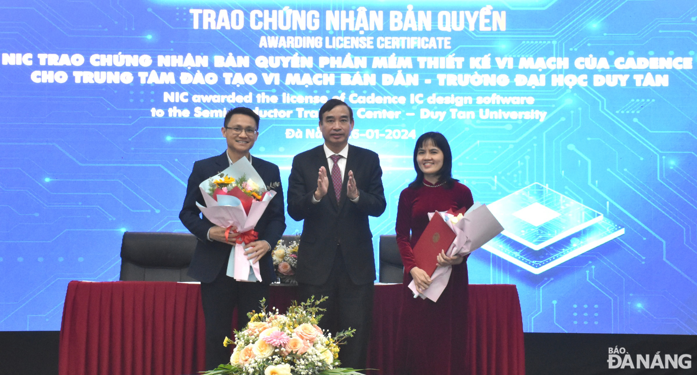 Chairman of the Da Nang People's Committee Le Trung Chinh (middle) congratulating the Duy Tan University's Semiconductor Circuit Training Center on receiving a copyright certificate for Cadence's IC design software. Photo: HOANG HIEP - THU HA