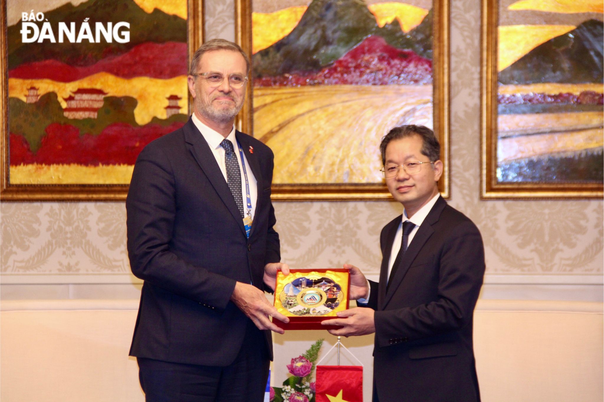 Da Nang Party Committee Secretary Nguyen Van Quang (R) presenting a souvenir gift to French Ambassador Extraordinary and Plenipotentiary to Viet Nam Olivier Brochet. Photo: P.V