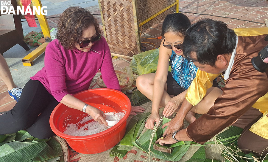 Many tourists express their excitement at experiencing the wrapping of 'banh chung' and 'banh tet' at the programme. Photo: THU HA