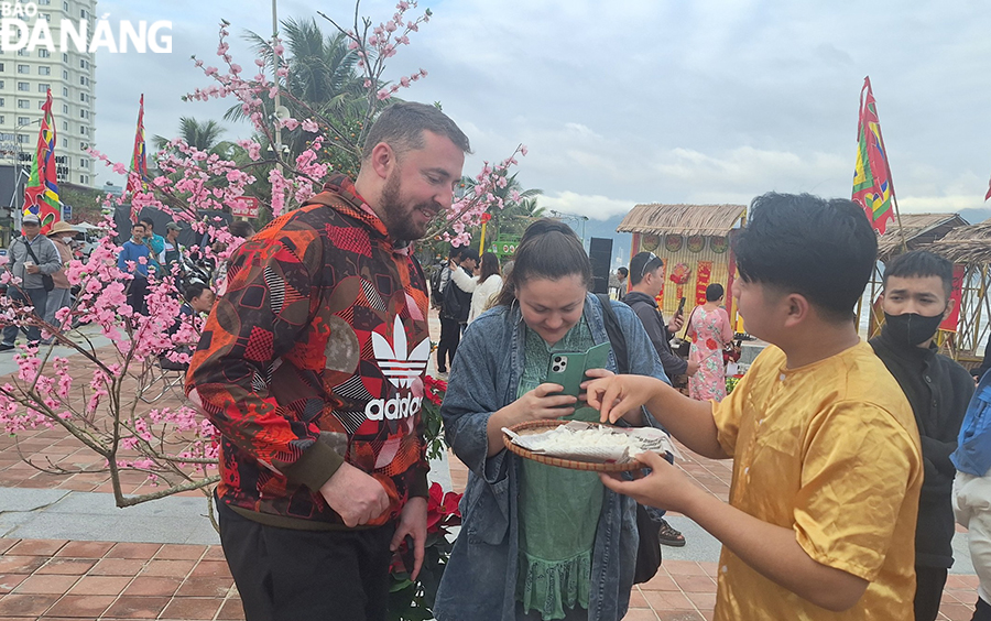 Foreign tourists experiencing freshly made coconut jam. Photo: THU HA