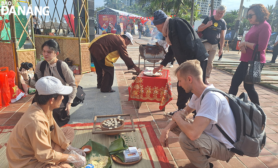 A foreigner watching the process of making printed cakes. Photo: THU HA