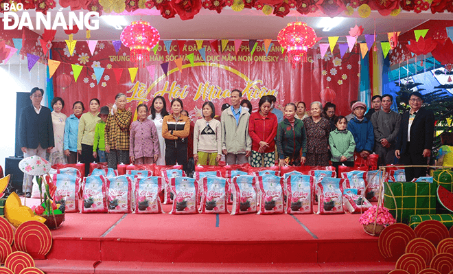 OneSky Centre representative (8th, left) gives gifts to households in difficult circumstances in the city.