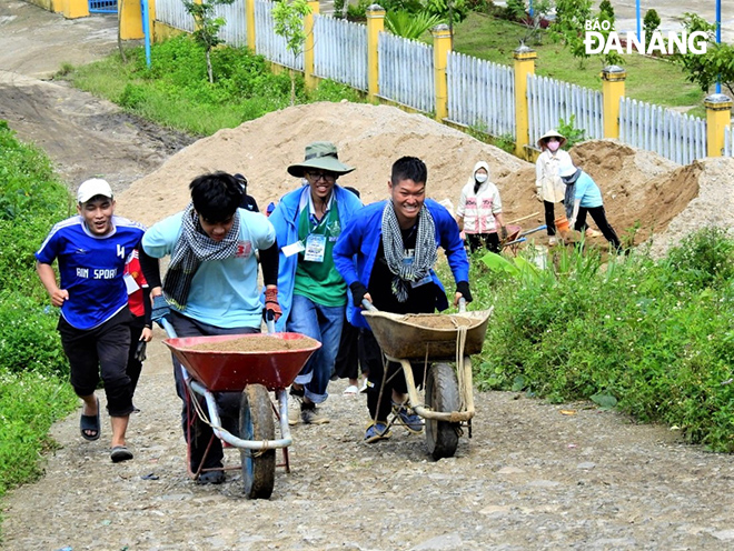 Volunteers of the Hand In Hand group of the University of Science and Education (UED) -UD transport materials to build a children's playground. Photo: L.P