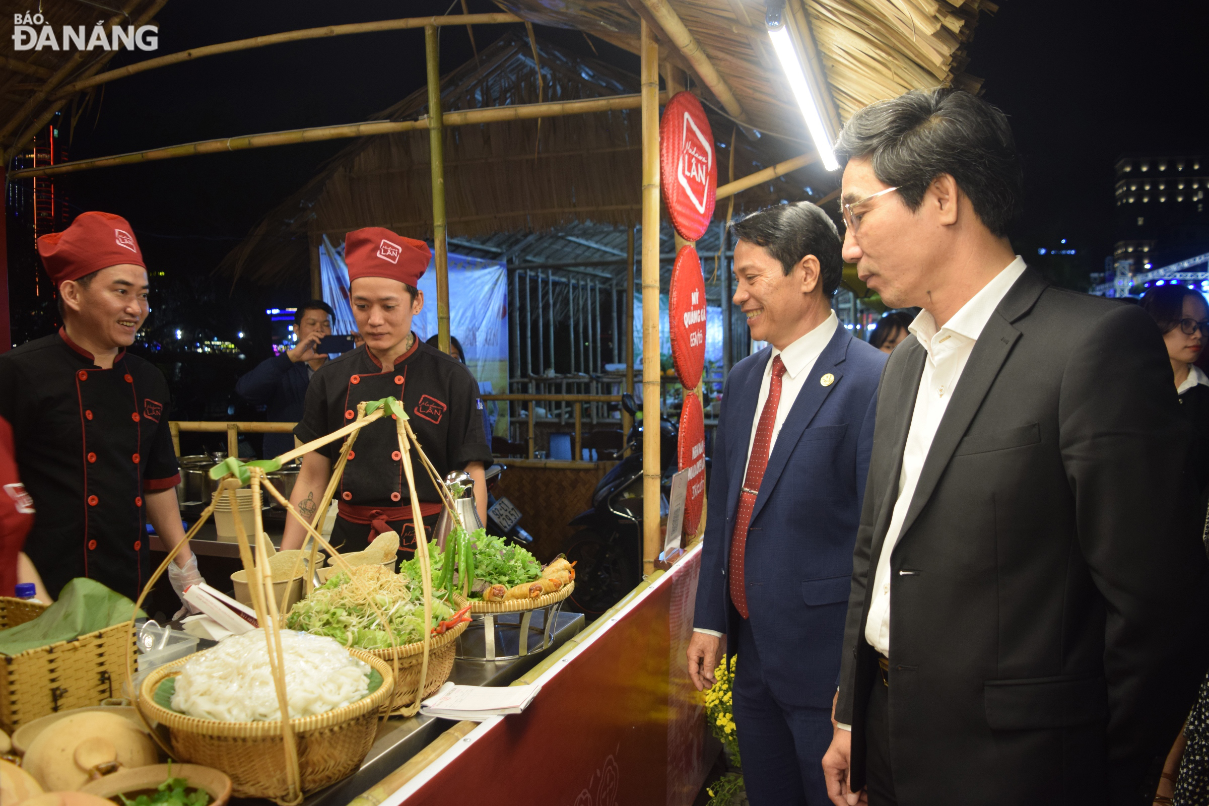 Vice Chairman of the Da Nang People's Committee Tran Chi Cuong (first right) and Vice Chairman of Son Tra District People's Committee Huynh Van Hung (second right) visit a food stall at the festival. Photo: HOANG HIEP