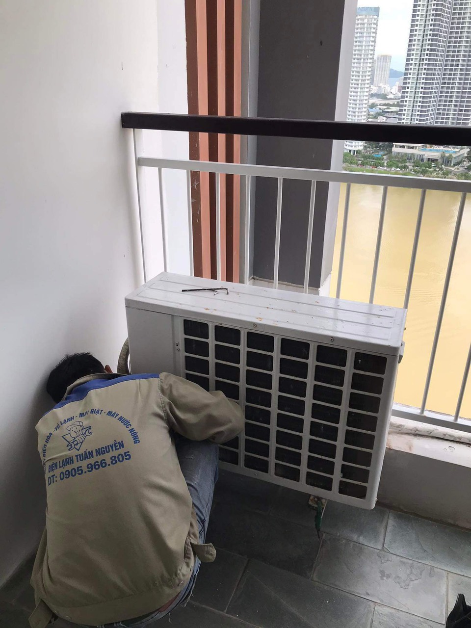 Thợ điện lạnh Tuấn Nguyễn đang tiến hành sửa chữa điều hòa cho khách.