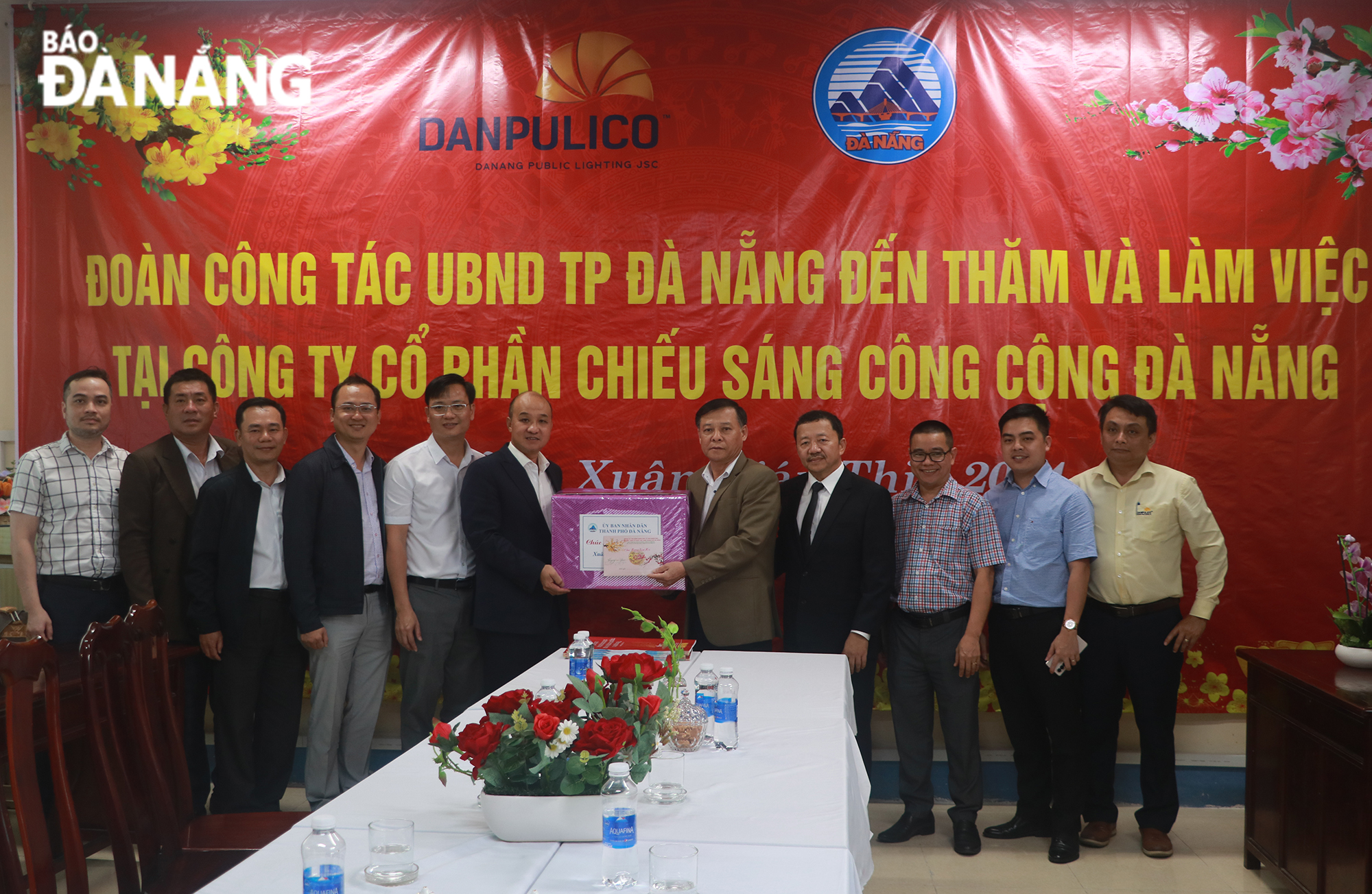 Phó Chủ tịch UBND thành phố Lê Quang Nam (thứ 5, bên trái sang) tặng quà cho Công ty CP Chiếu sáng công cộng Đà Nẵng trong chiều 6-2. Ảnh: VĂN HOÀNG