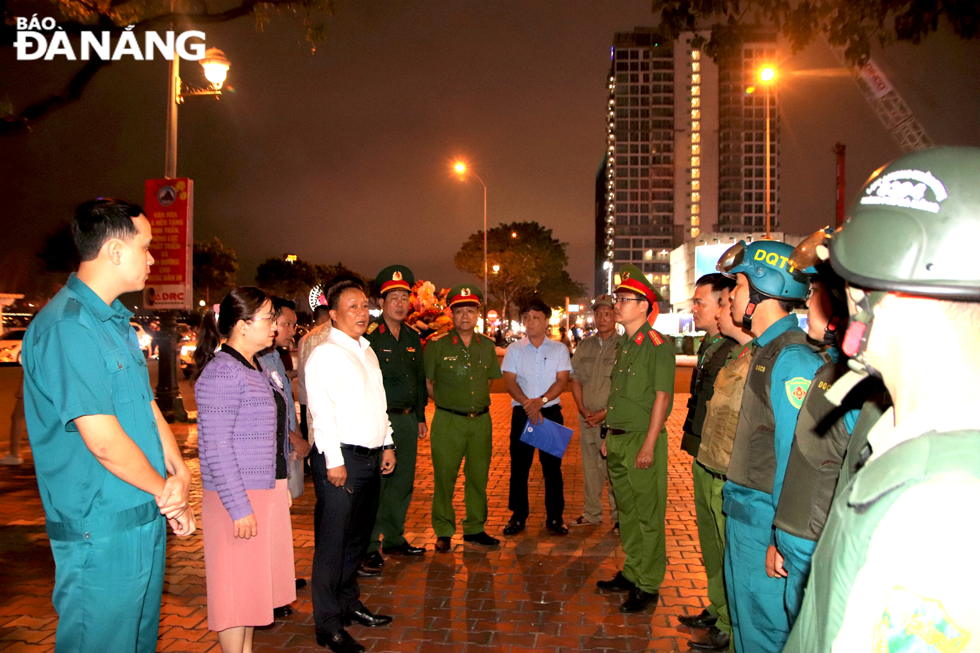 Chủ tịch UBND quận hải Châu Lê Tự Gia Thạnh (Áo trắng, bên trái) nhắc nhở, động viên lực lượng tuần tra 8394 tại khu vực Côn viên Apec. Ảnh: T. HUY