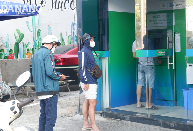 Người dân xếp hàng chờ rút tiền nhưng không quá lâu tại ATM của Ngân hàng TMCP Việt Nam Thịnh Vượng (523 Điện Biên Phủ, quận Thanh Khê).. Ảnh: M.Q