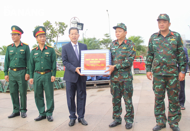 Bí thư Thành ủy Nguyễn Văn Quảng (giữa) tặng quà động viên lực lượng quân sự tại điểm bắn pháo hoa giao thừa. Ảnh: M.Q