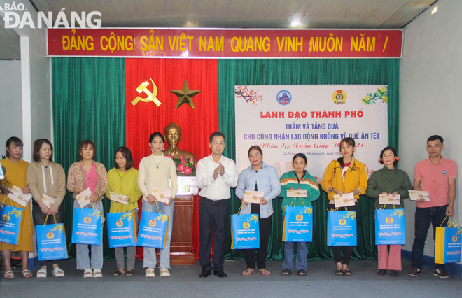 Bí thư Thành ủy Nguyễn Văn Quảng (giữa) trao quà Tết cho người lao động khó khăn. Ảnh: M.Q