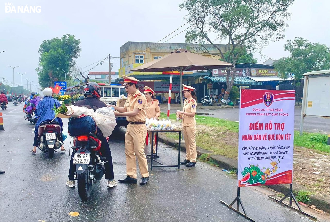 Từ sáng sớm, lực lượng Cảnh sát giao thông (Công an thành phố) đã ứng trực tại các điểm hỗ trợ để trao quà cho người lao động xa quê. Ảnh: KIM KHÁNH