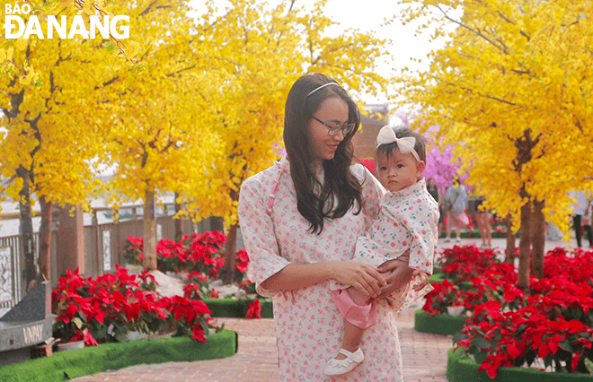 Mrs. Nguyen Thi Thuy Trang and her family go to the Bach Dang flower street to take pictures to welcome in the lunar new year. This is her family's annual habit. 