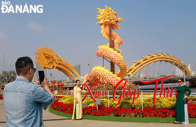 Dragon mascot statues on Bach Dang Street attract tourists to take photos