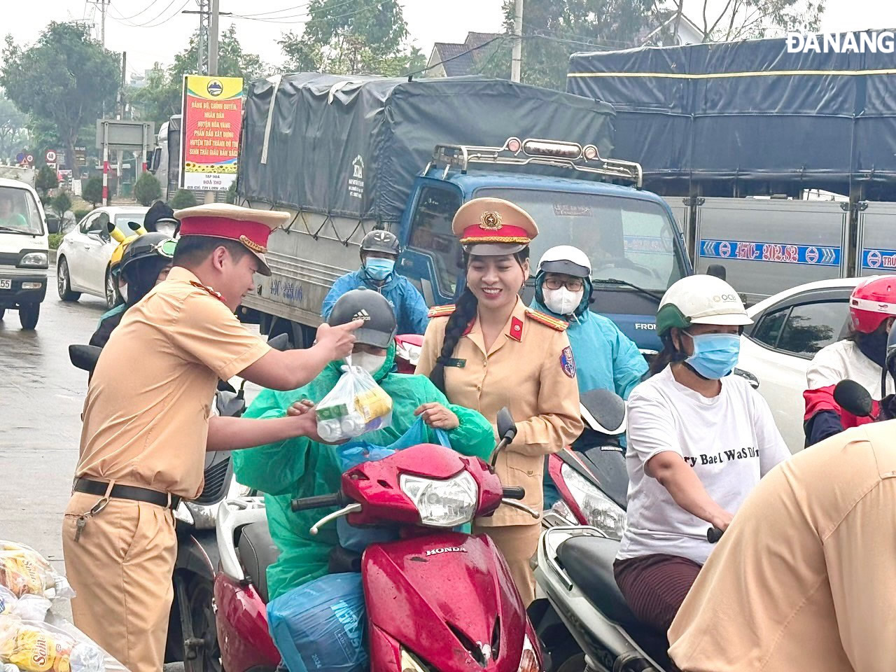 Besides distributing gifts, the traffic police officers also remind people to pay attention to safety when travelling by motorbike. Photo: KIM KHANH