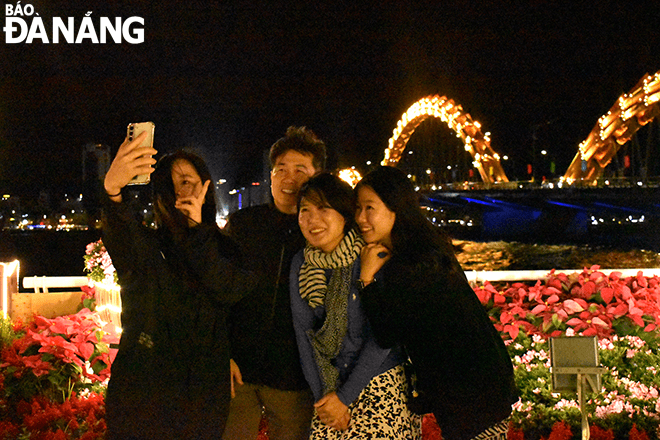 Gia đình du khách Hàn Quốc chụp ành kỷ niệm, hòa cùng không khí đón Tết của người dân thành phố.