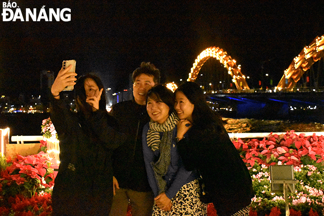 A South Korean family posing for a selfie photo, joining the Tet atmosphere of the people of Da Nang.