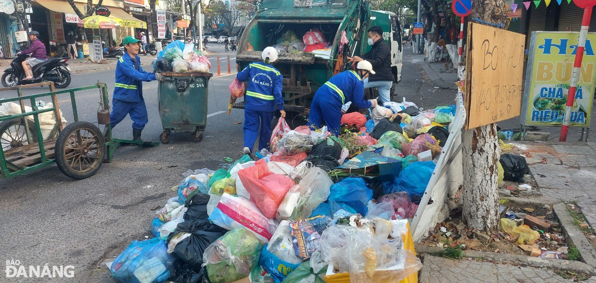 Các công nhân Xí nghiệp Môi trường Hải Châu nỗ lực thu gom rác do người dân thải bỏ sau 3 ngày Tết. Ảnh: HOÀNG HIỆP