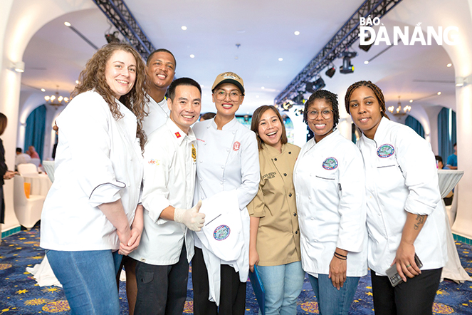 Runner-up of MasterChef Viet Nam 2015 Pham Thi Tuyet (centre) takes a photo with chefs from the US Navy delegation in June 2023. Photo: VAN HOANG