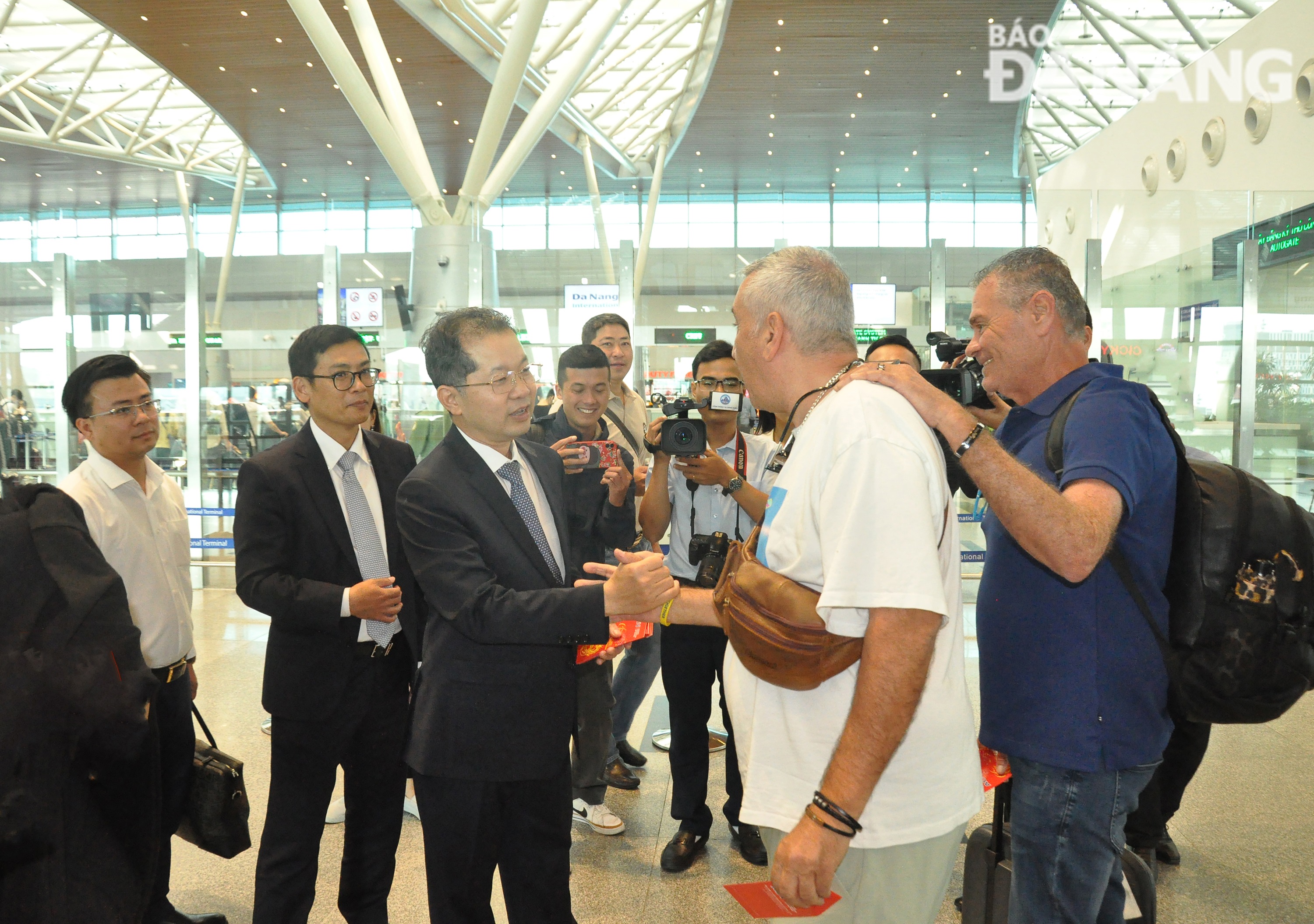 Secretary Nguyen Van Quang giving lucky money to tourists. Photo: THANH LAN